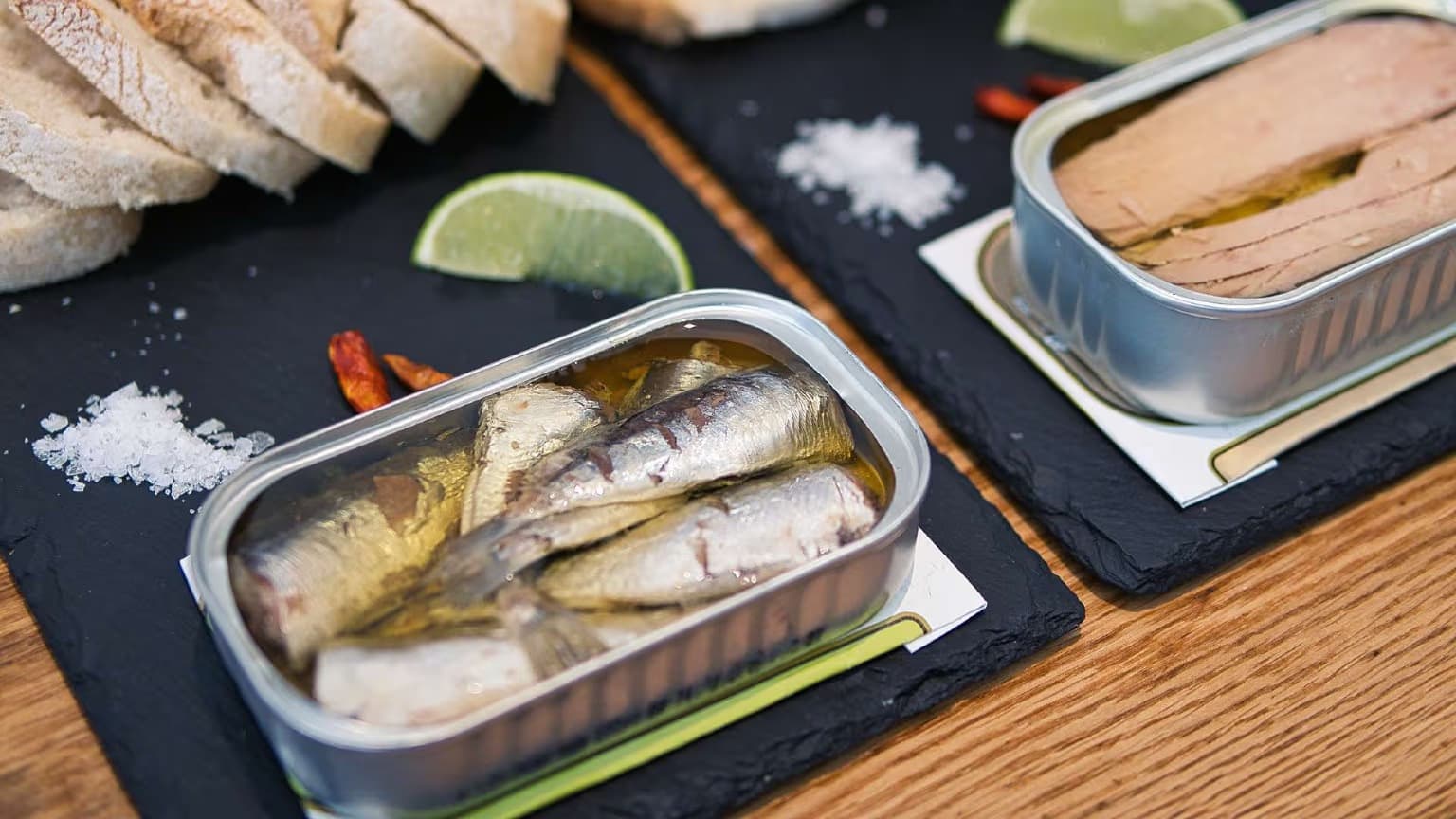 Colorful vintage-style tins of Portuguese sardines and other conservas arranged on wooden shelves in a traditional Lisbon conservas shop, with ornate packaging designs showcasing the artisanal heritage of Portuguese tinned fish